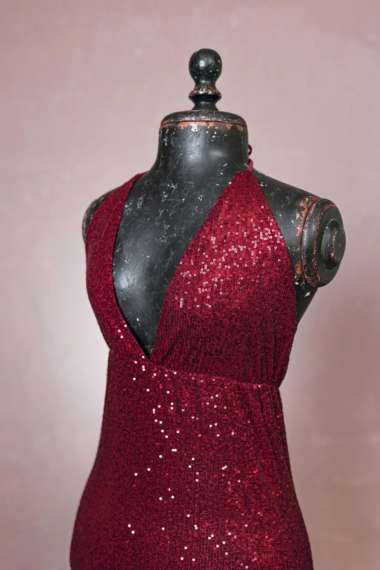 Close up of red sparkly sequin form-fitting designer gown, showing v-neck