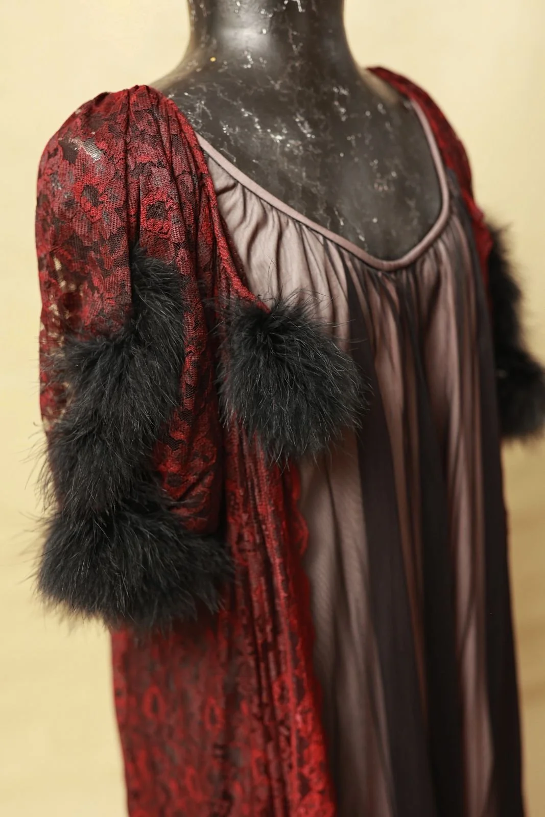 Close up of smoky black vintage boudoir slip dress, with red robe that has fur trim