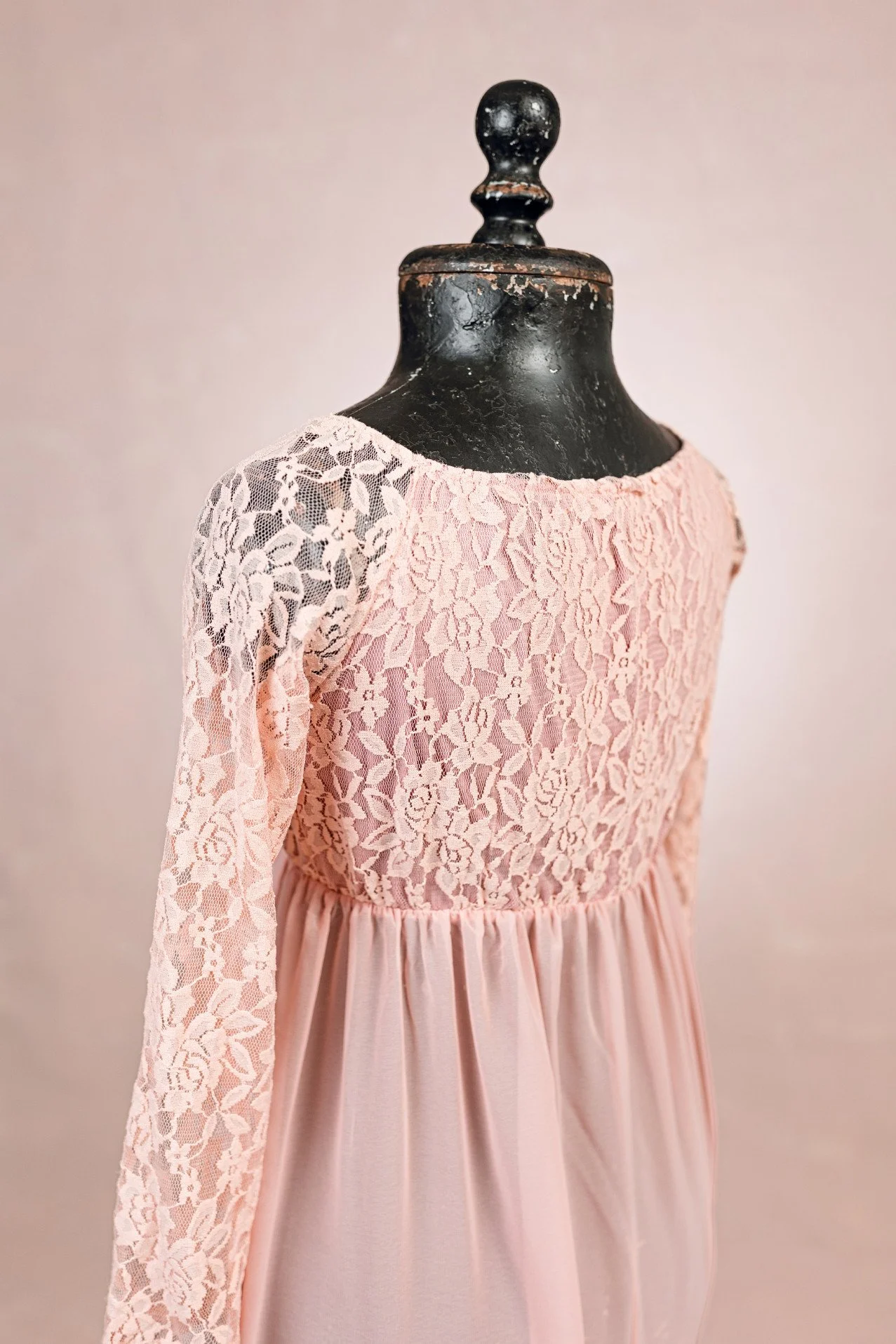 Back view of peach pink maternity photoshoot rental dress, showing lace upper with closed back and long sleeves