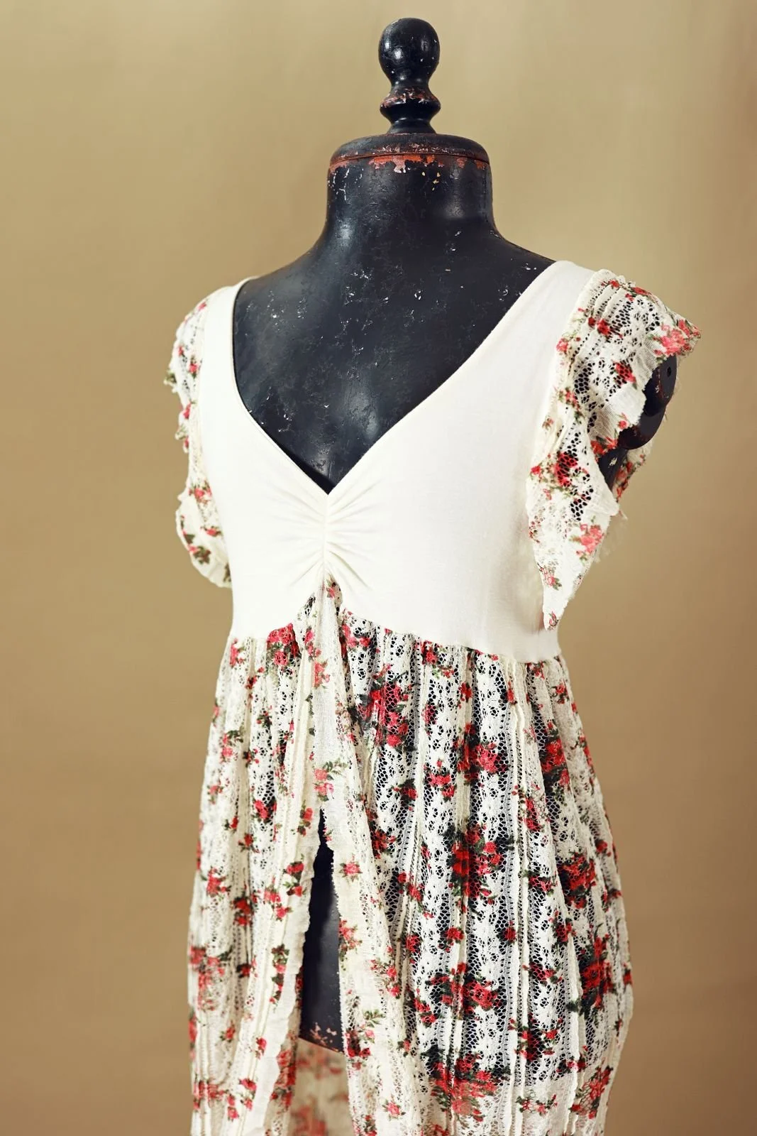 Close up of white maternity bodycon dress with cinched white top and floral lace skirt