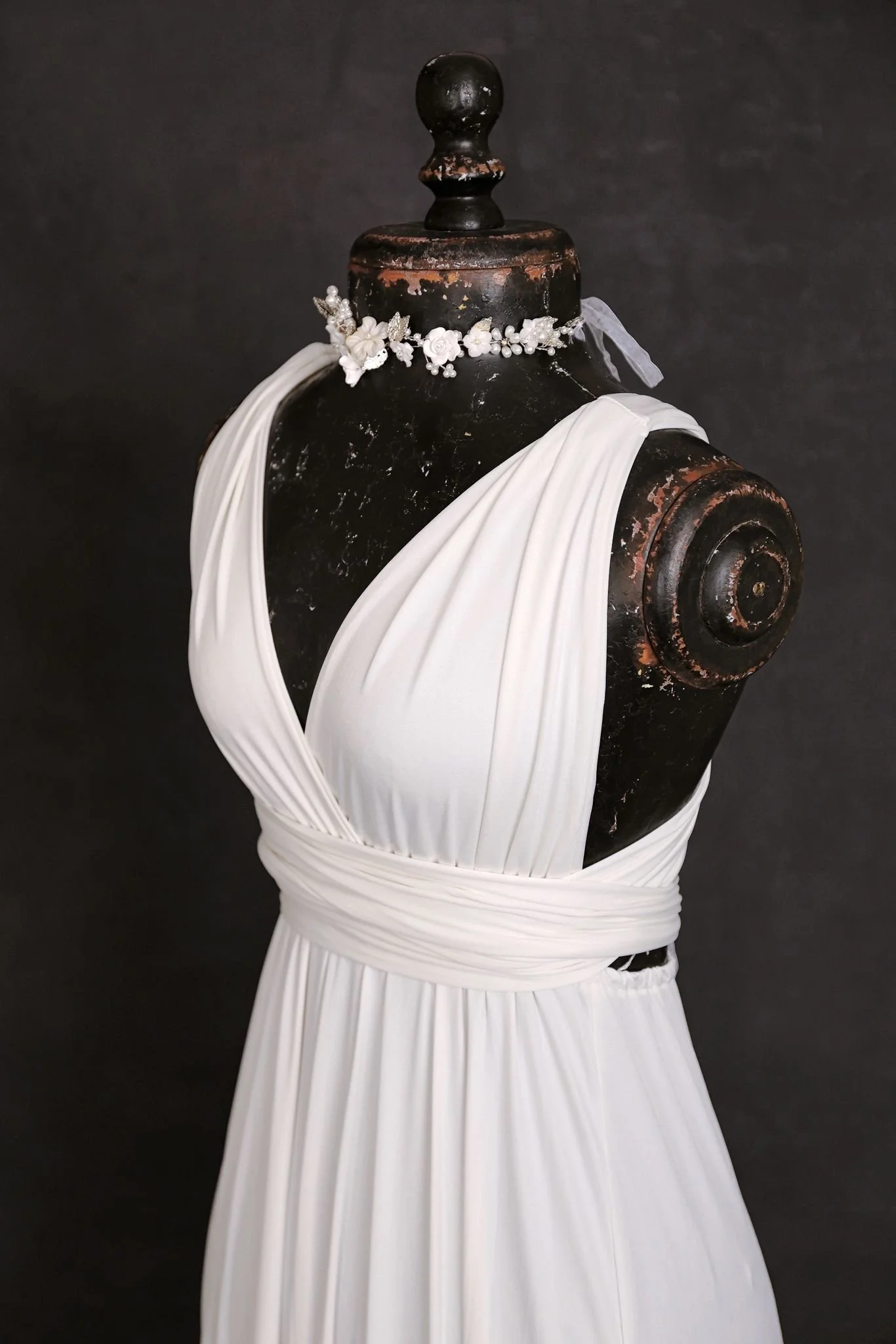 Close up of white maternity and engagement infinity dress, with silver jewellery ribbon