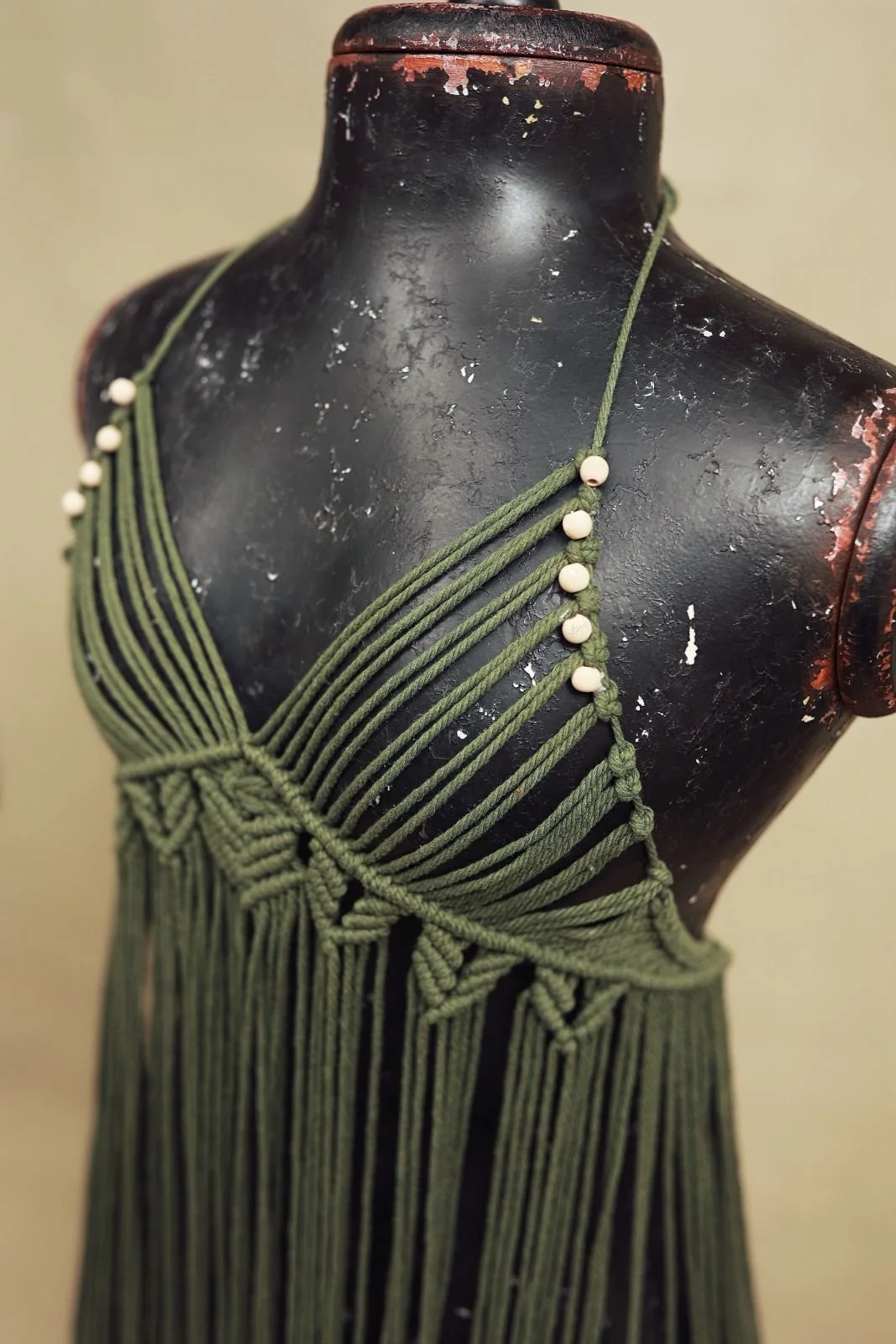 Close up of green boho rope macrame dress, showing sleeveless cut