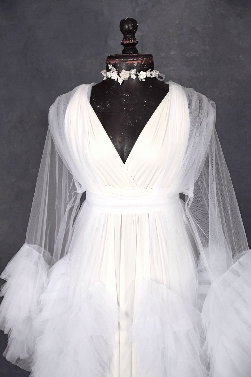 Close up of white infinity dress, with a sheer white tulle robe, and silver jewellery ribbon