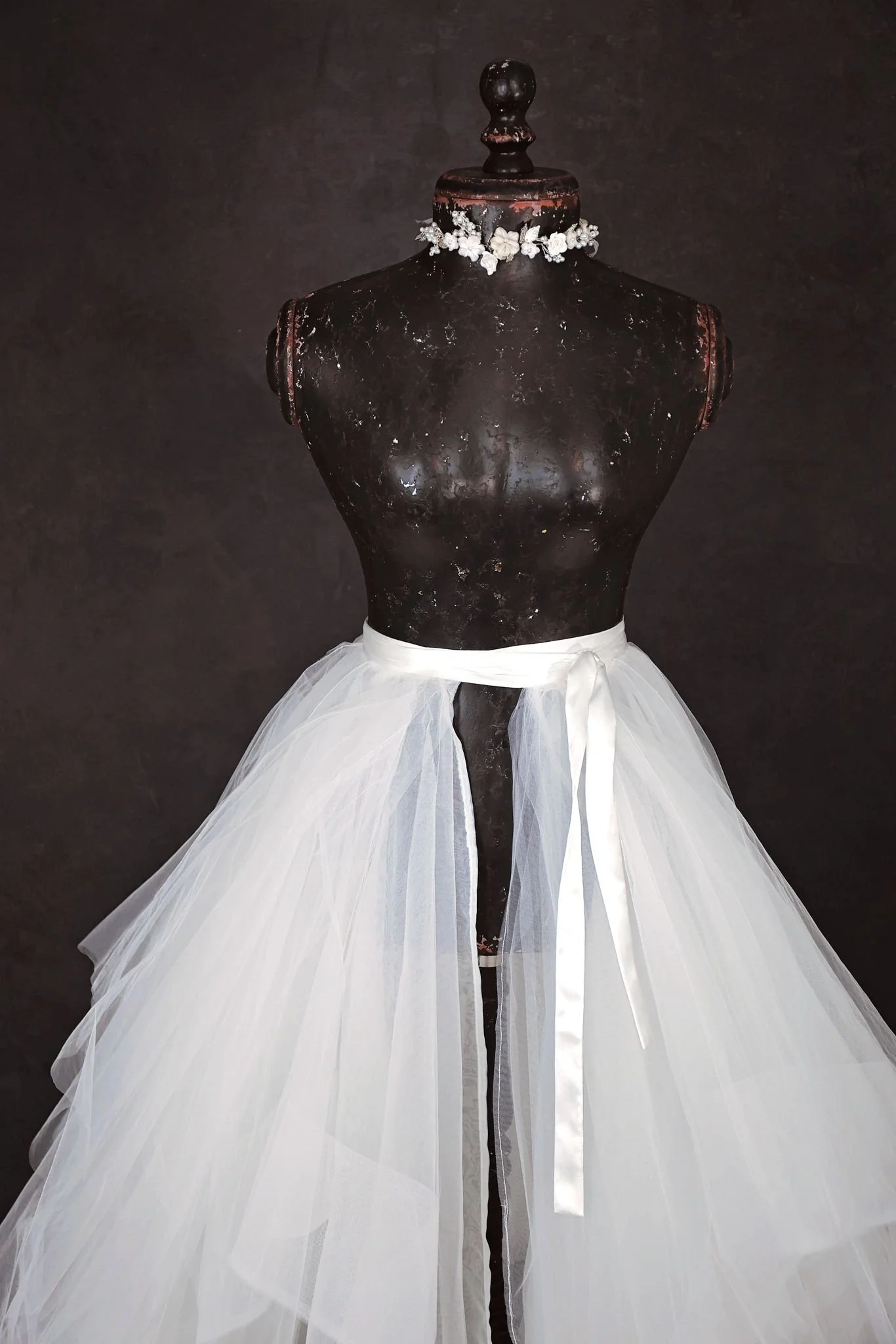 Close up of white layered tulle skirt and silver jewellery ribbon