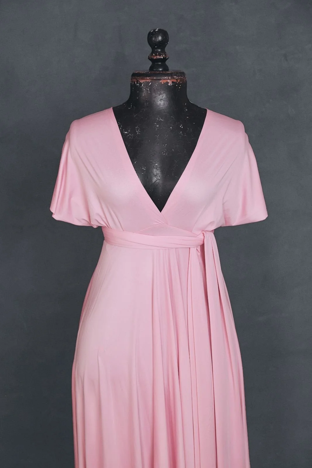Close up of a pink photoshoot infinity dress with a V-neck cut