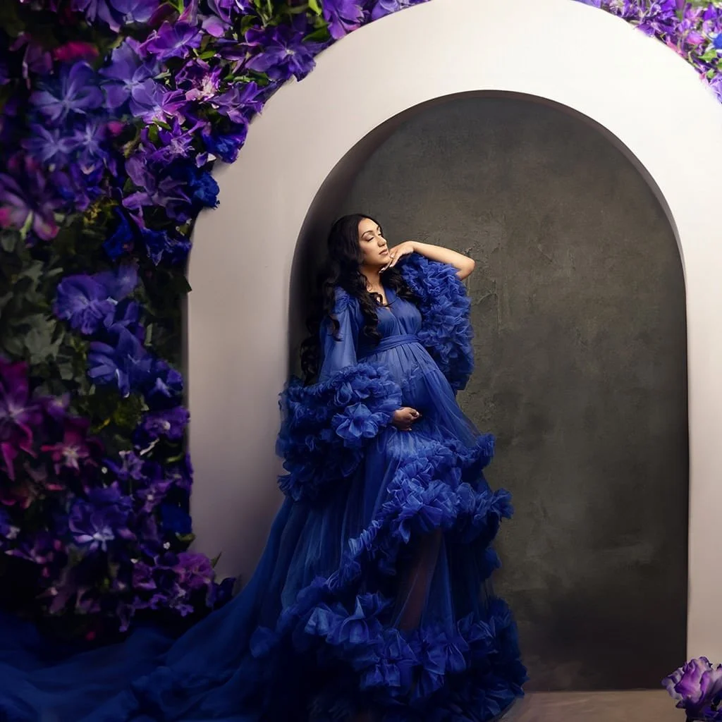 Pregnant woman wearing a blue tulle maternity gown for rent, in a maternity photoshoot in Calgary
