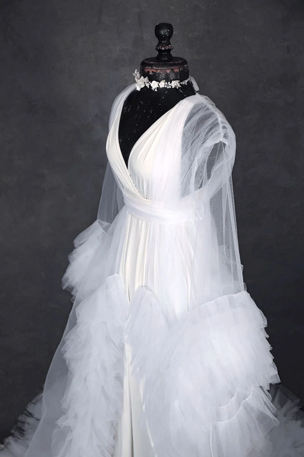 Close up of white infinity dress, with a sheer white tulle robe, and silver jewellery ribbon