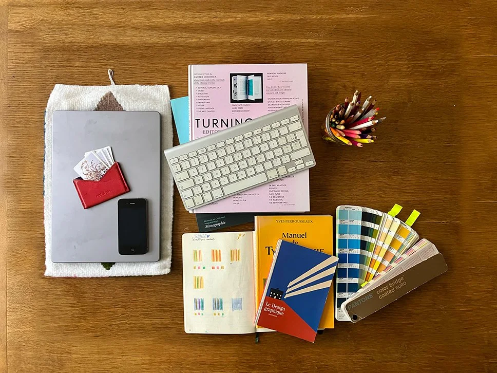 Objets utiles pour une bonne feuille de route graphique - nuancier pantone, livres d’inspiration, crayons de couleur, croquis de recherche
