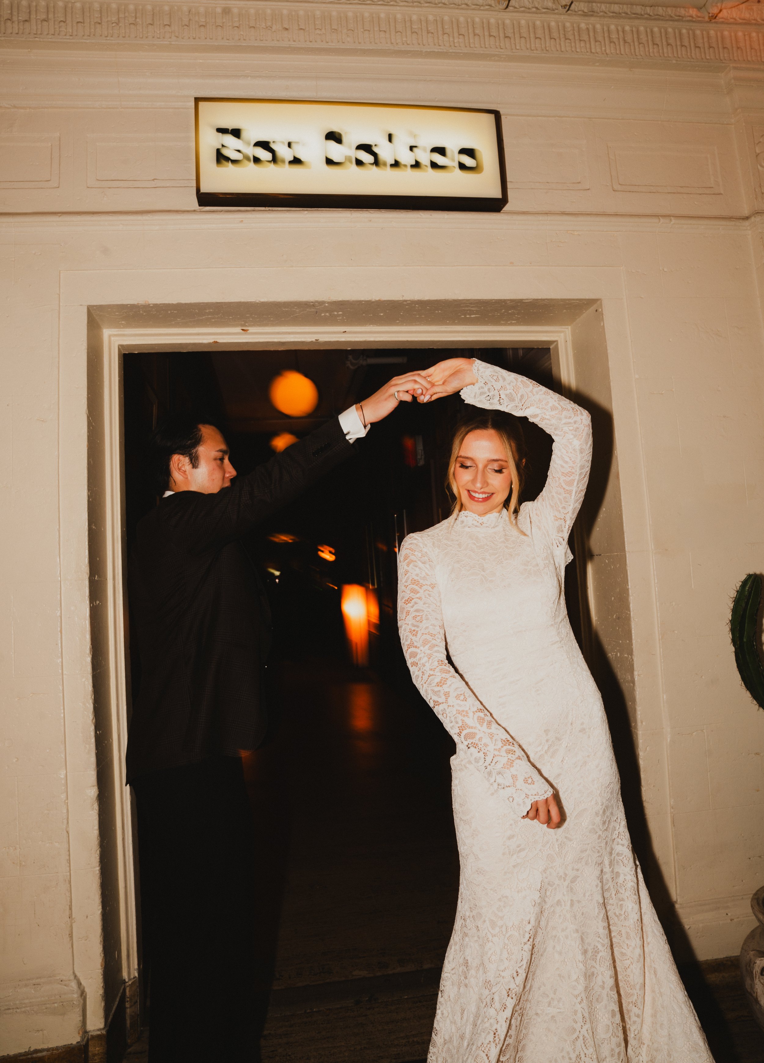 An engagement couple dancing under the Bar Calico sign