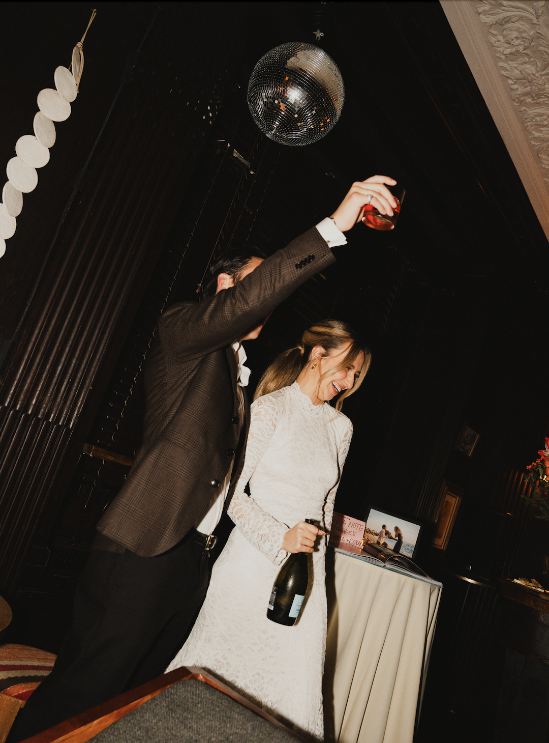 An engagement couple doing a toast with their guests under the disco ball in Bar Calico