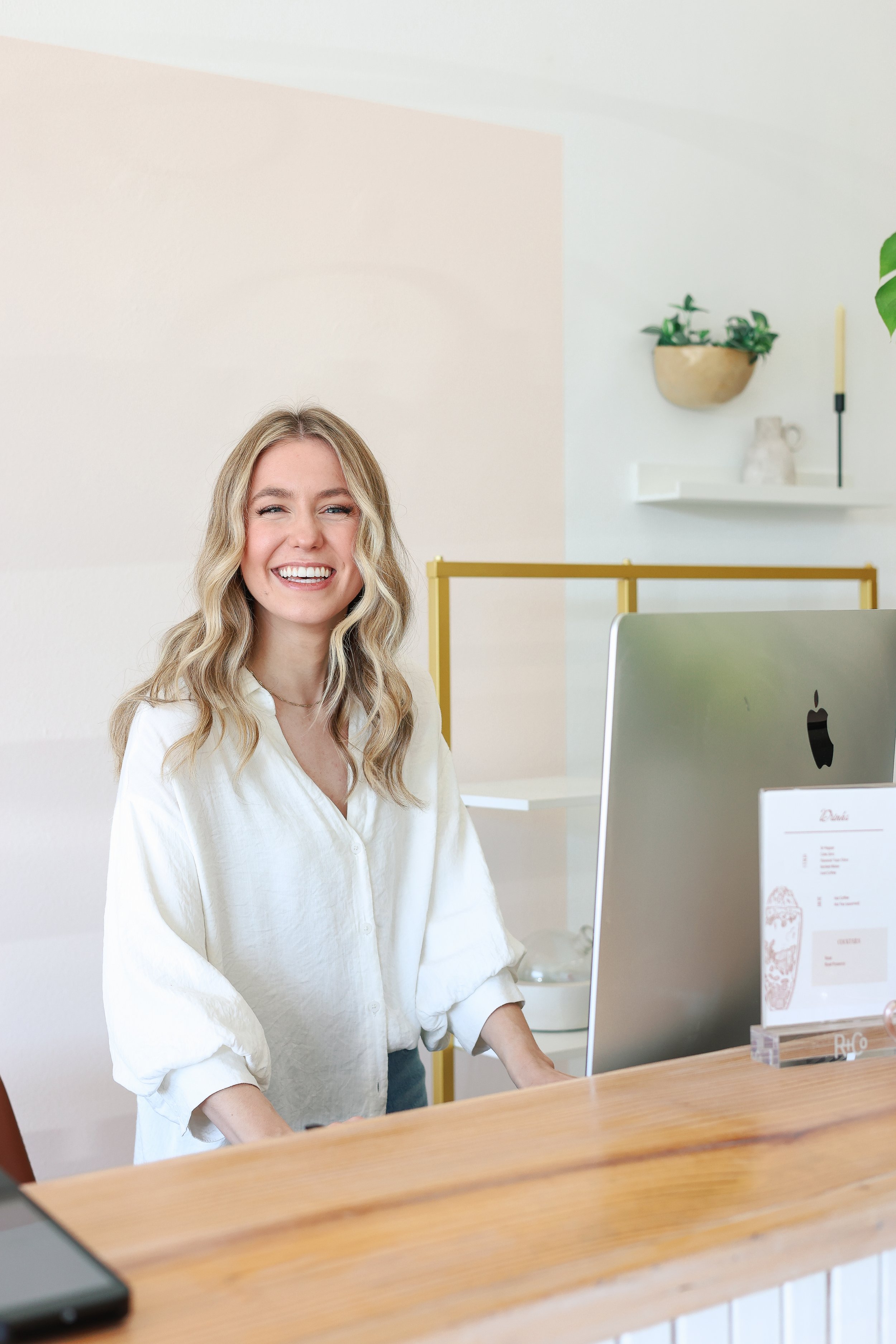 Friendly salon receptionist at the front desk of Dwell Studio Salon.