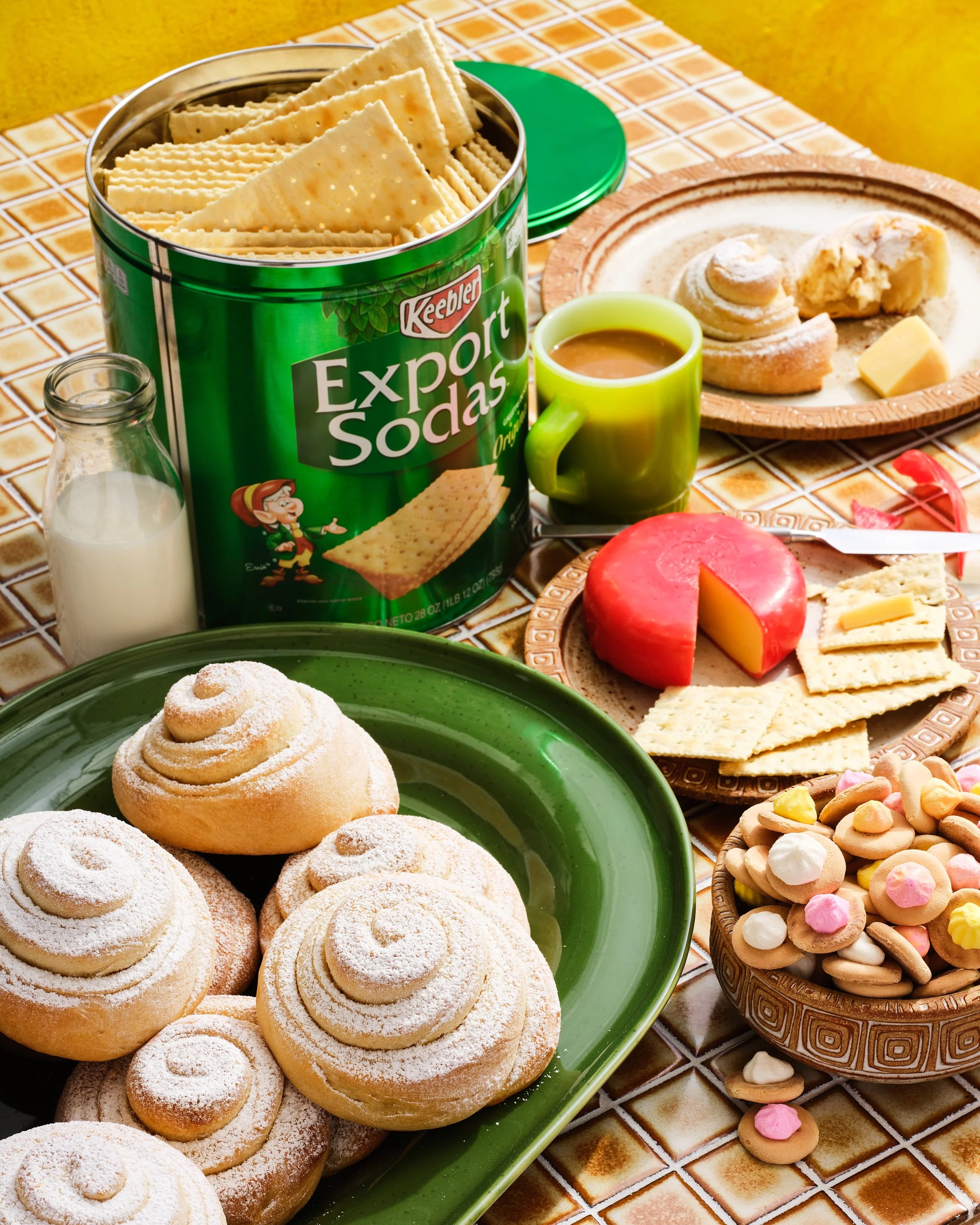 Kitchen table with a bountiful spread of cookies, cheese and crackers