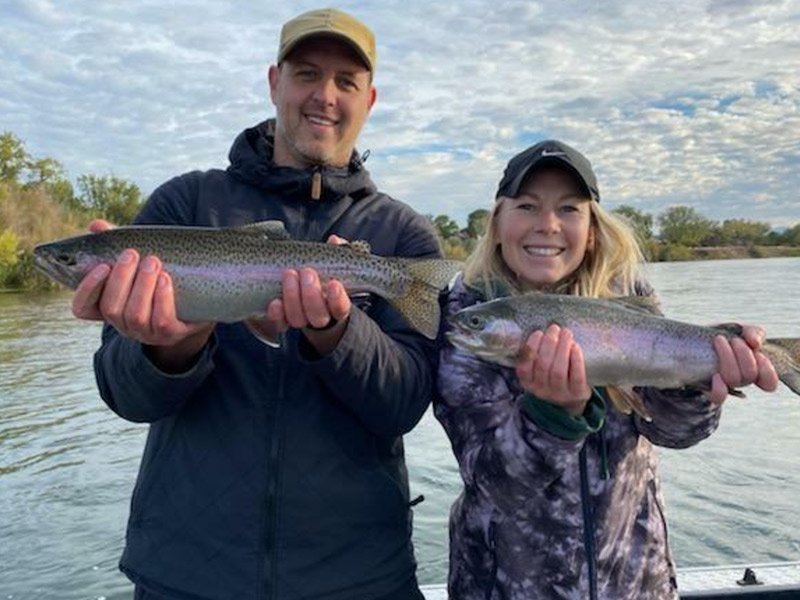 Man and Woman happily catch trout after trout fishing with fishing guide in Redding, California