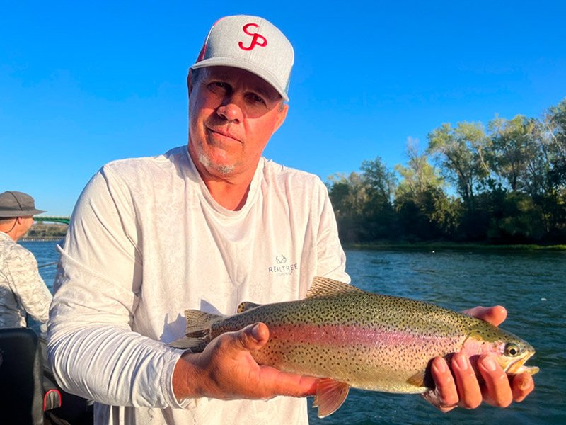 man holding trout he caught on the Sacramento river with a fishing expert