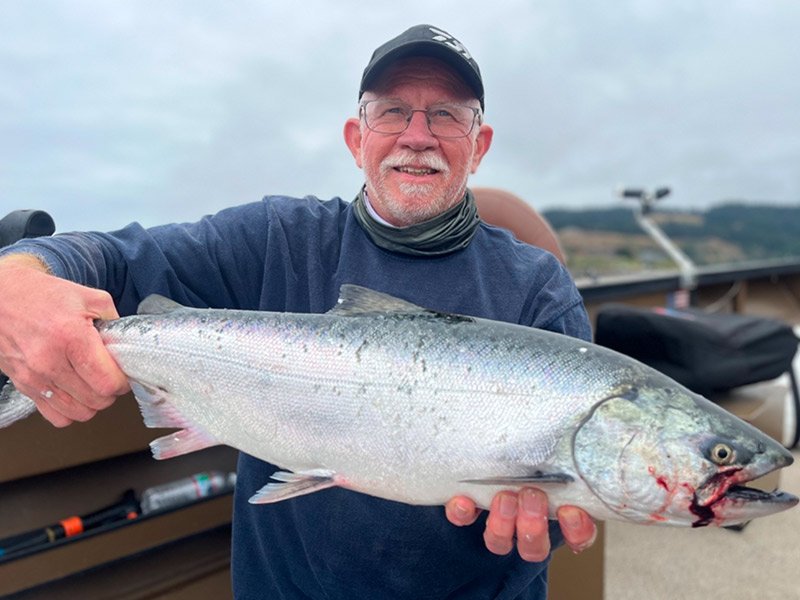 Man catches King salmon fish with fishing guide