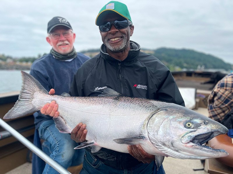 Two men catching King Salmon fish on Gold Beach