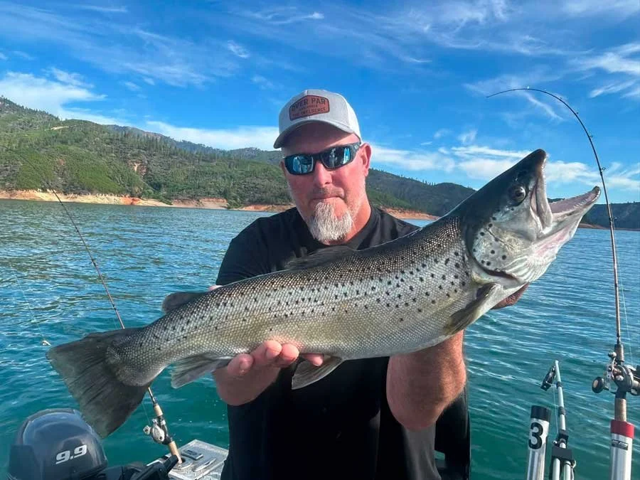 Man holding large fish on Shasta lake fishing with the best guide in Redding