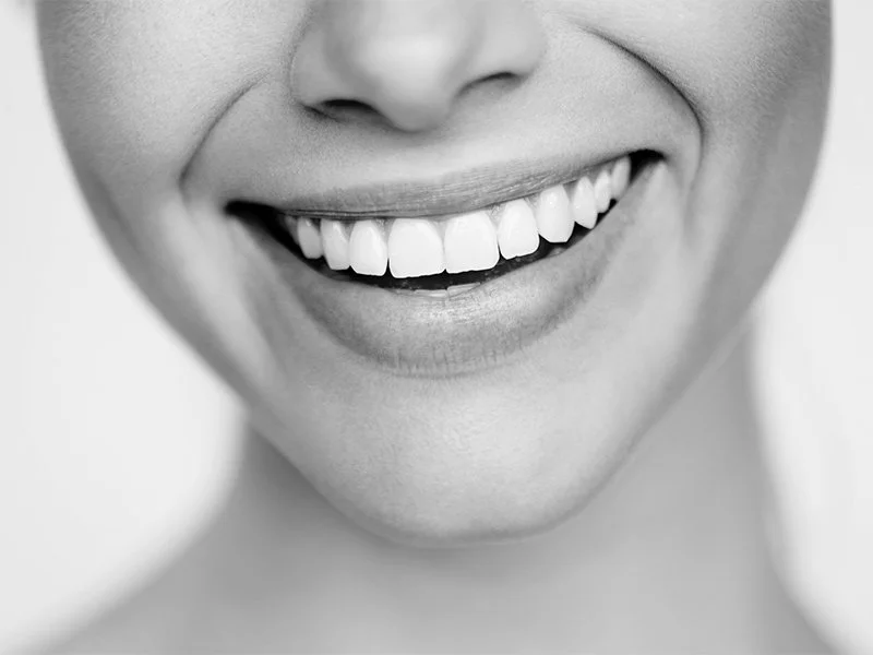 Woman smiling after relieving tooth ache at the dentist office