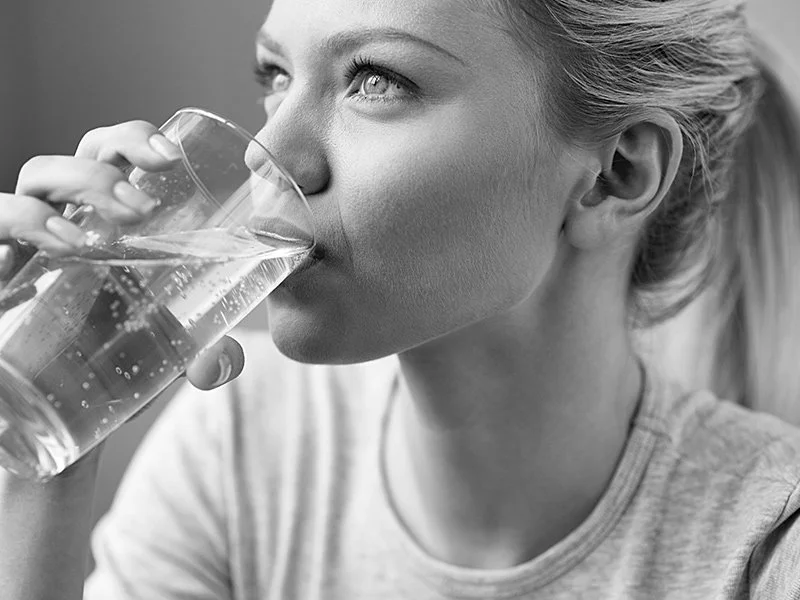 Woman drinking water to relieve her dry mouth