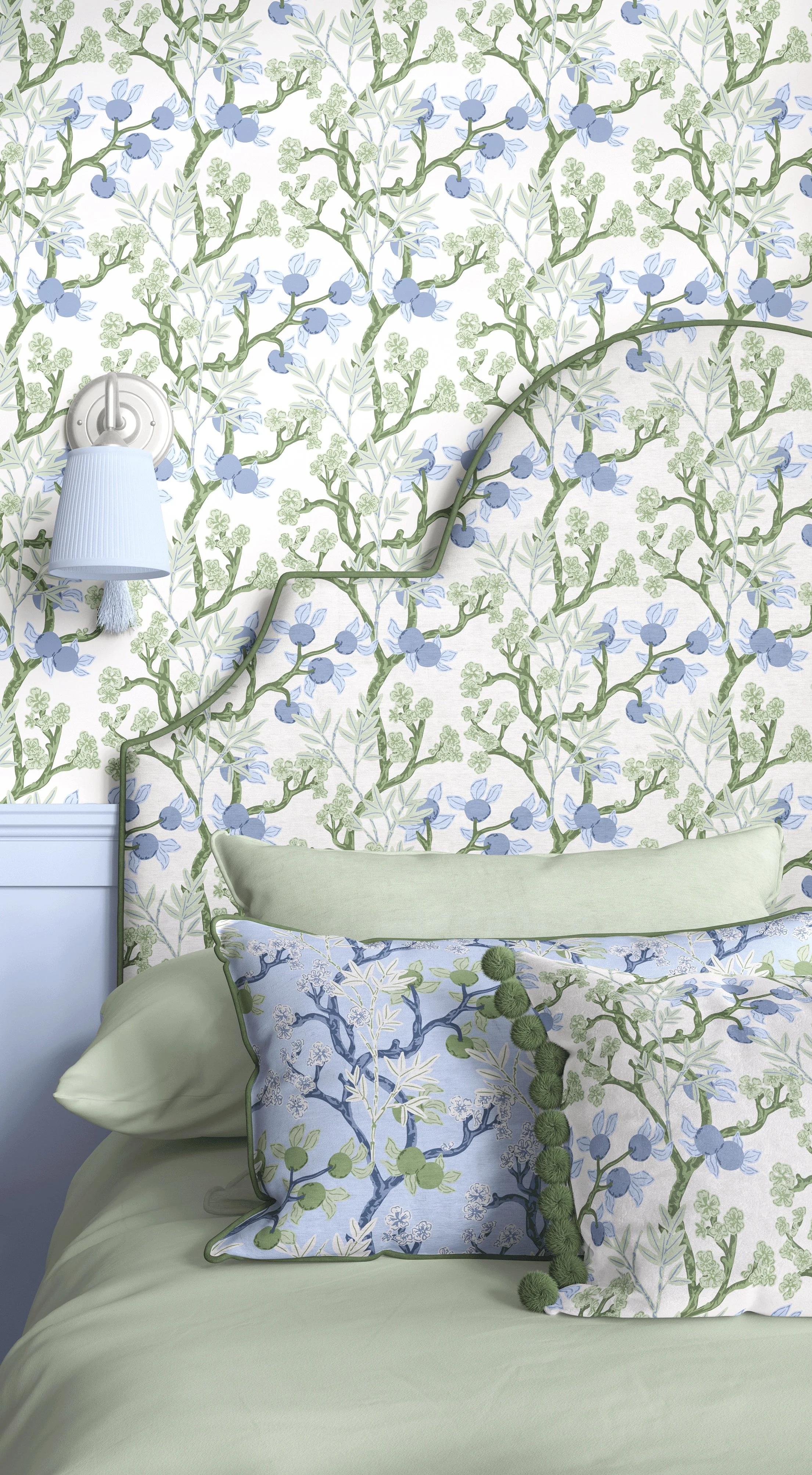 Bedroom scene with wallpaper, bed head, cushions and a lamp all covered in a chinoiseries branch pattern.