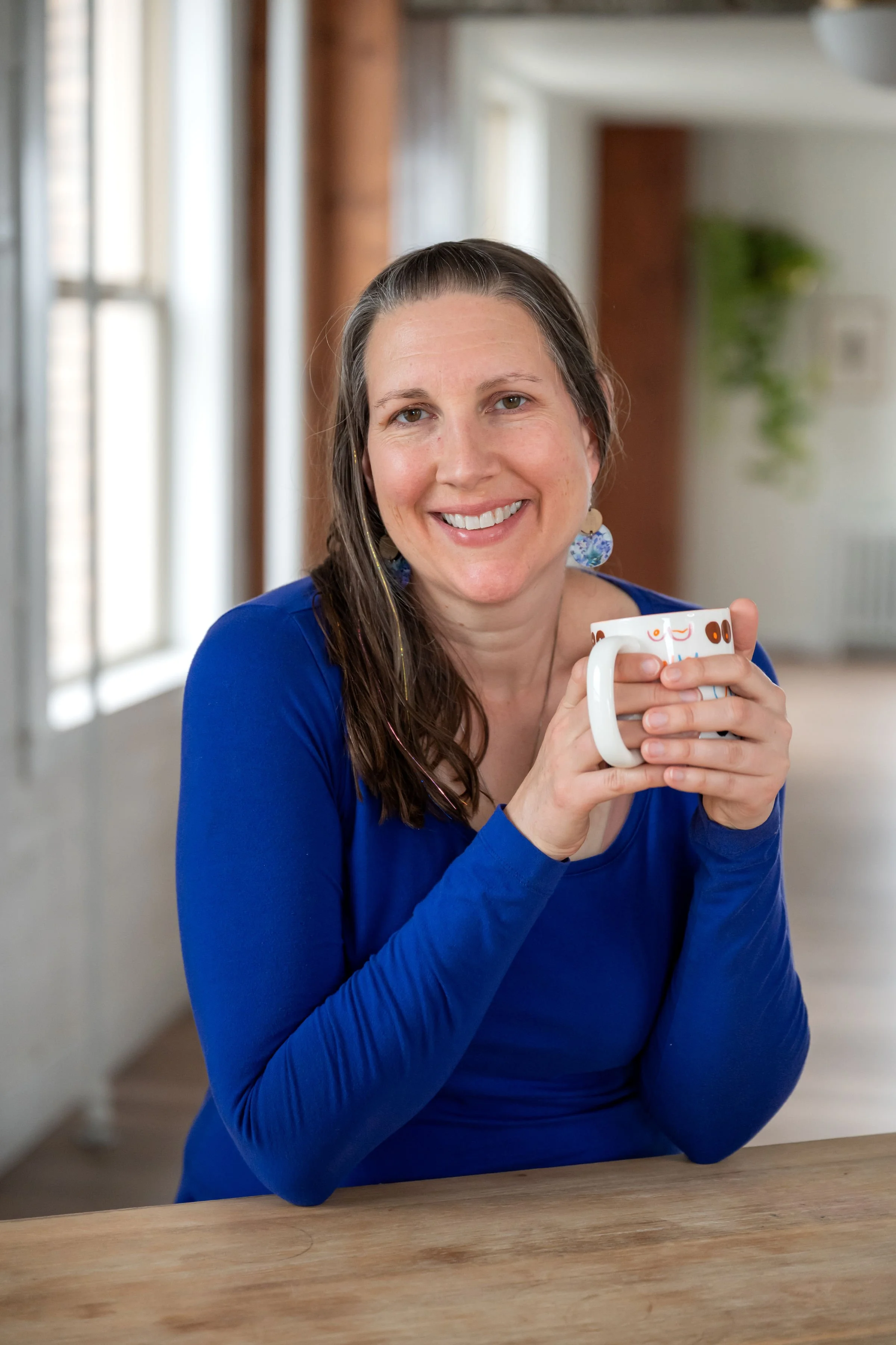 Cuddles and Milk lactation consultant smiling with baby photos displayed behind her