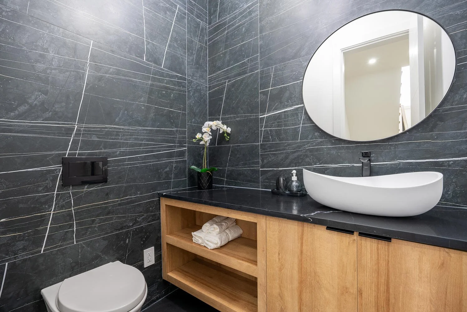 Designer bathroom with black tiled walls