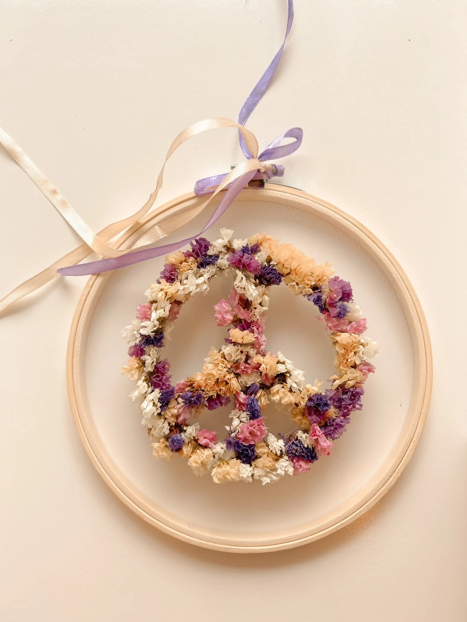 Blumenkranz in Form eines Friedenszeichens, auf einem runden Rahmen, mit Pastellfarbenen Ribbons