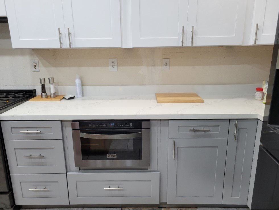 Kitchen: Light Grey base cabinet finish, shaker style and Cool White wall cabinet finish. Other finishes: chrome pull handles, and stainless steel appliances. 