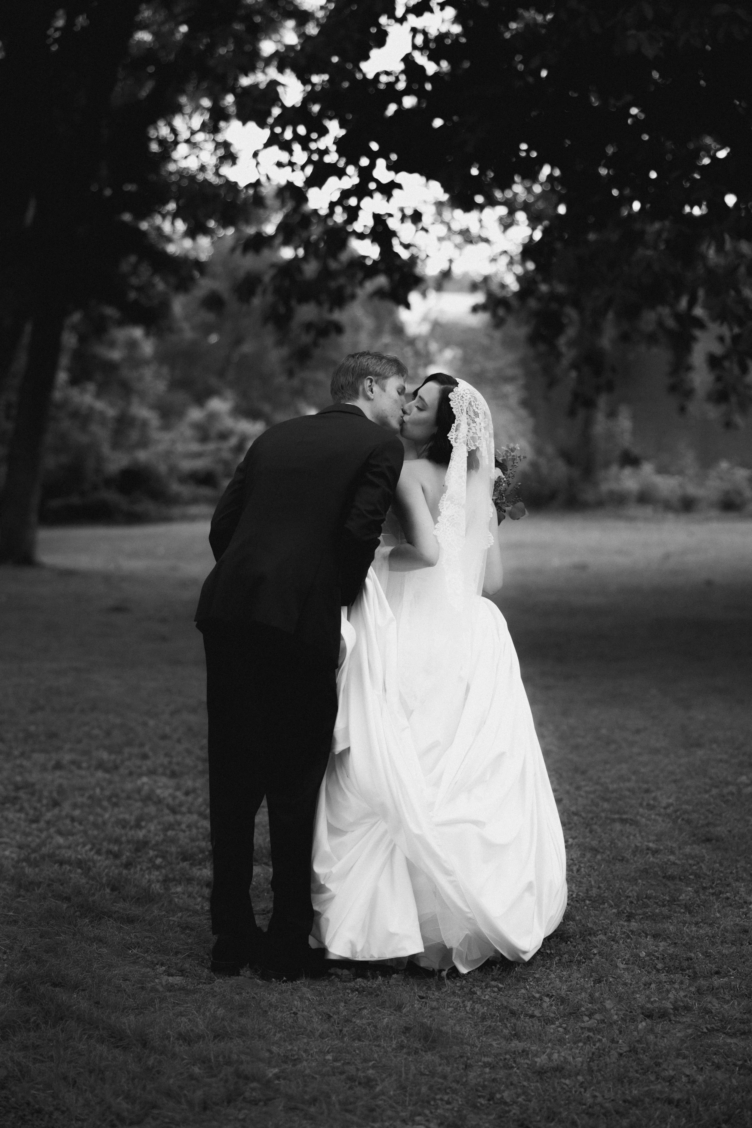 Black and white photo of newlyweds kissing