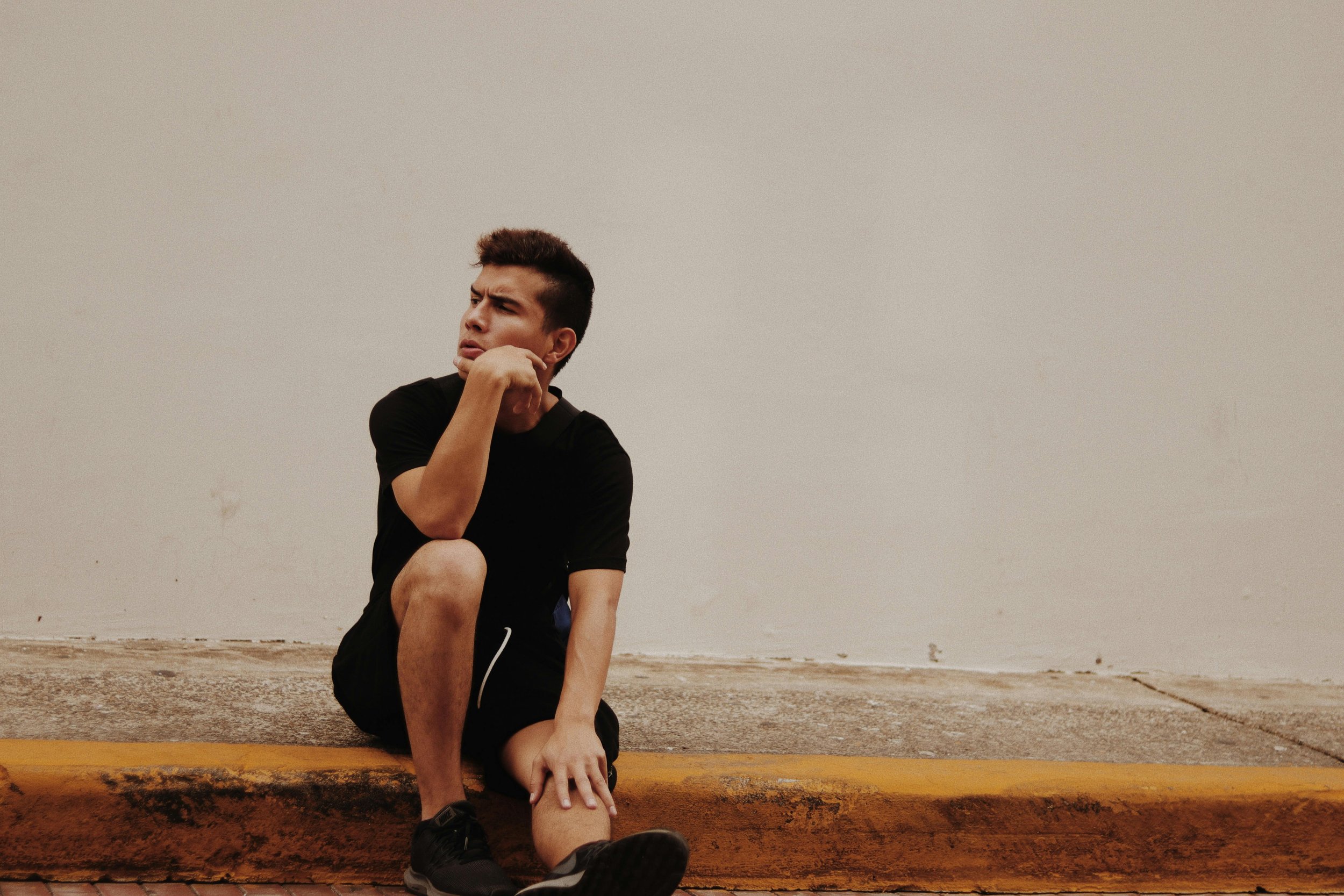 a man sits on a curb considering whether ketamine-assisted EMDR therapy may be right for him. Dr. Waldron provides therapy in San Francisco and Marin, CA.