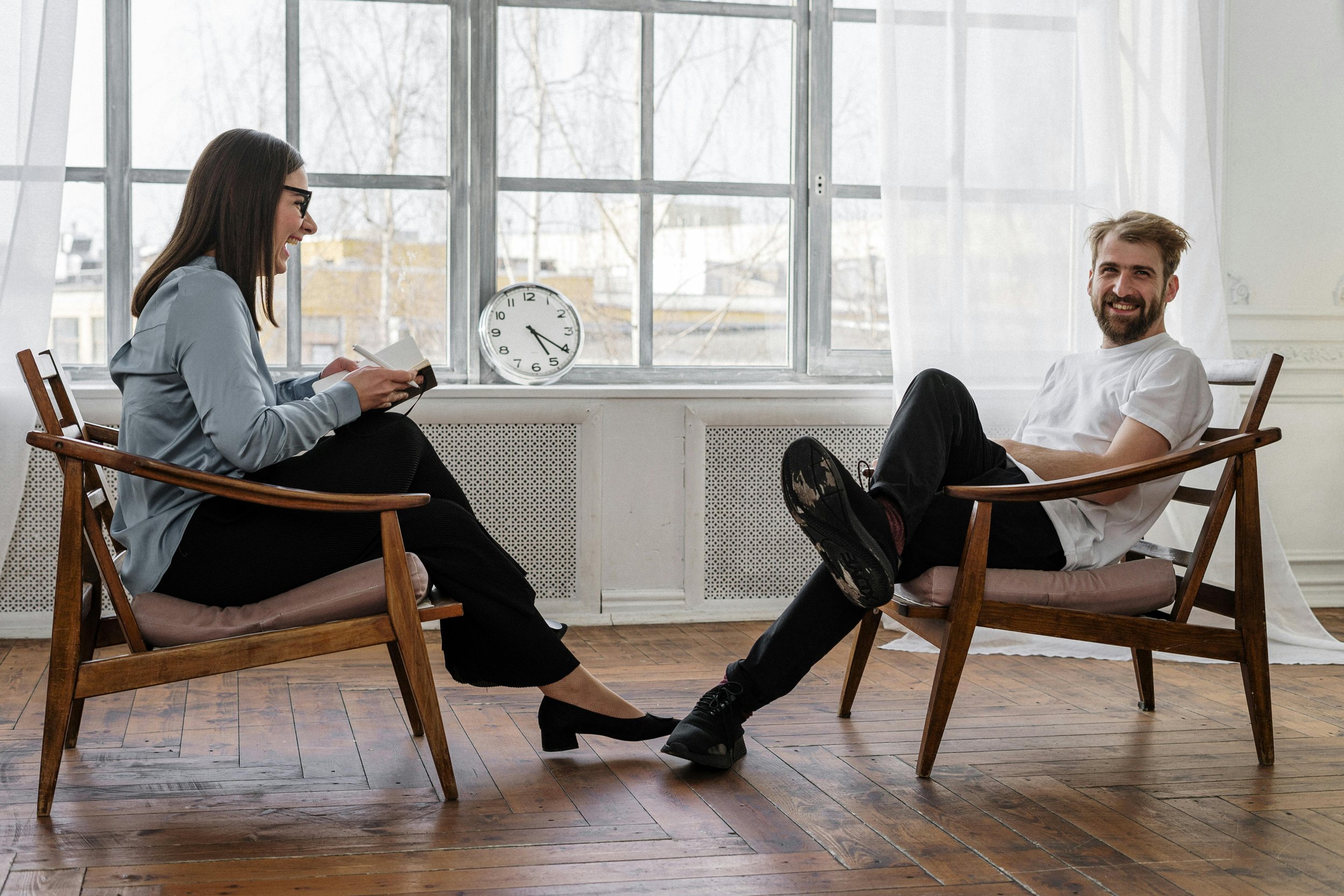 A client sits with his ketamine-assisted EMDR therapist to complete an intake. The pair laugh as they identify strenghts. Ketamine-assisted EMDR therapy can take place in person in SF or online in CA, NC, and FL.
