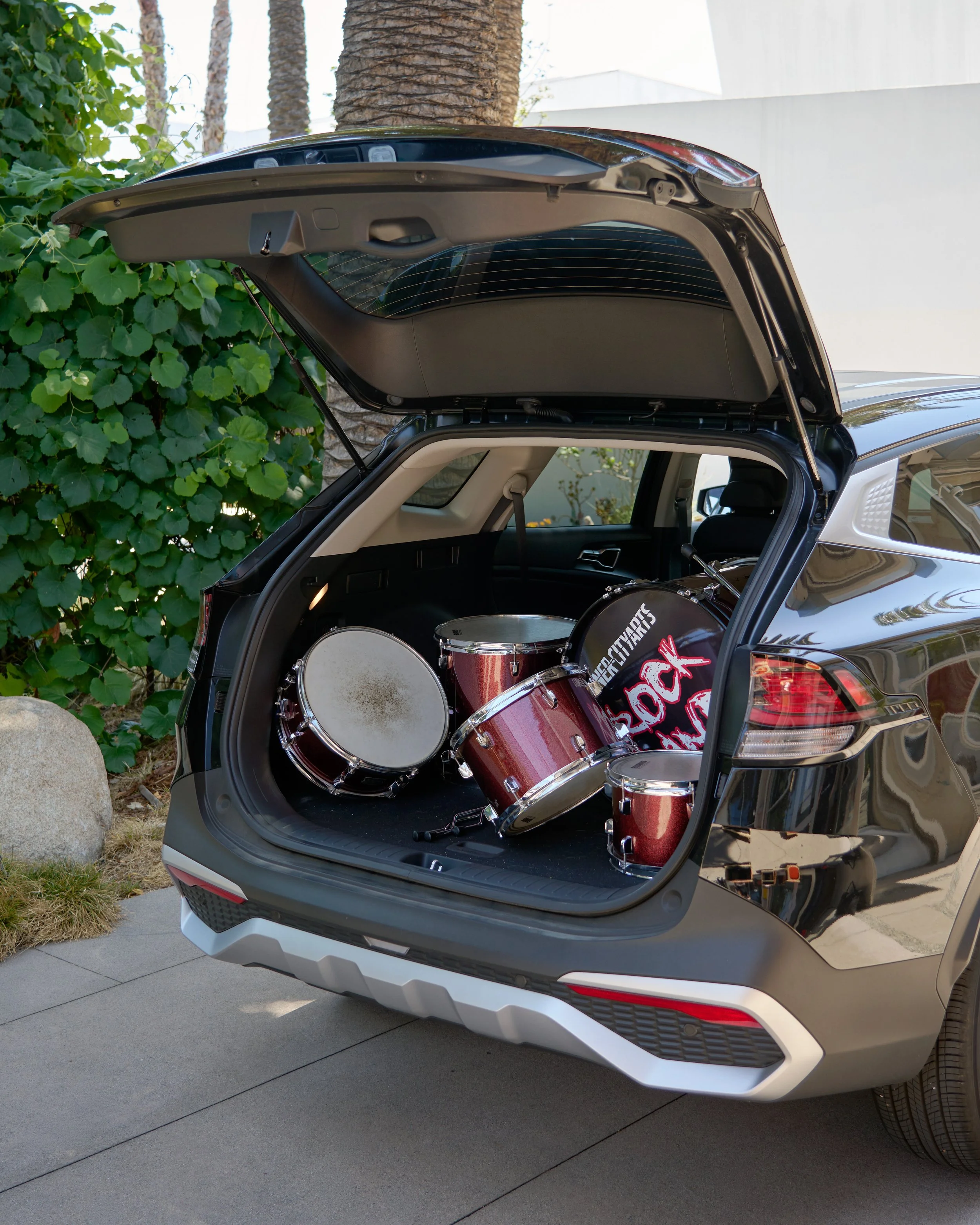 drums stacked dangerously in the back of a car