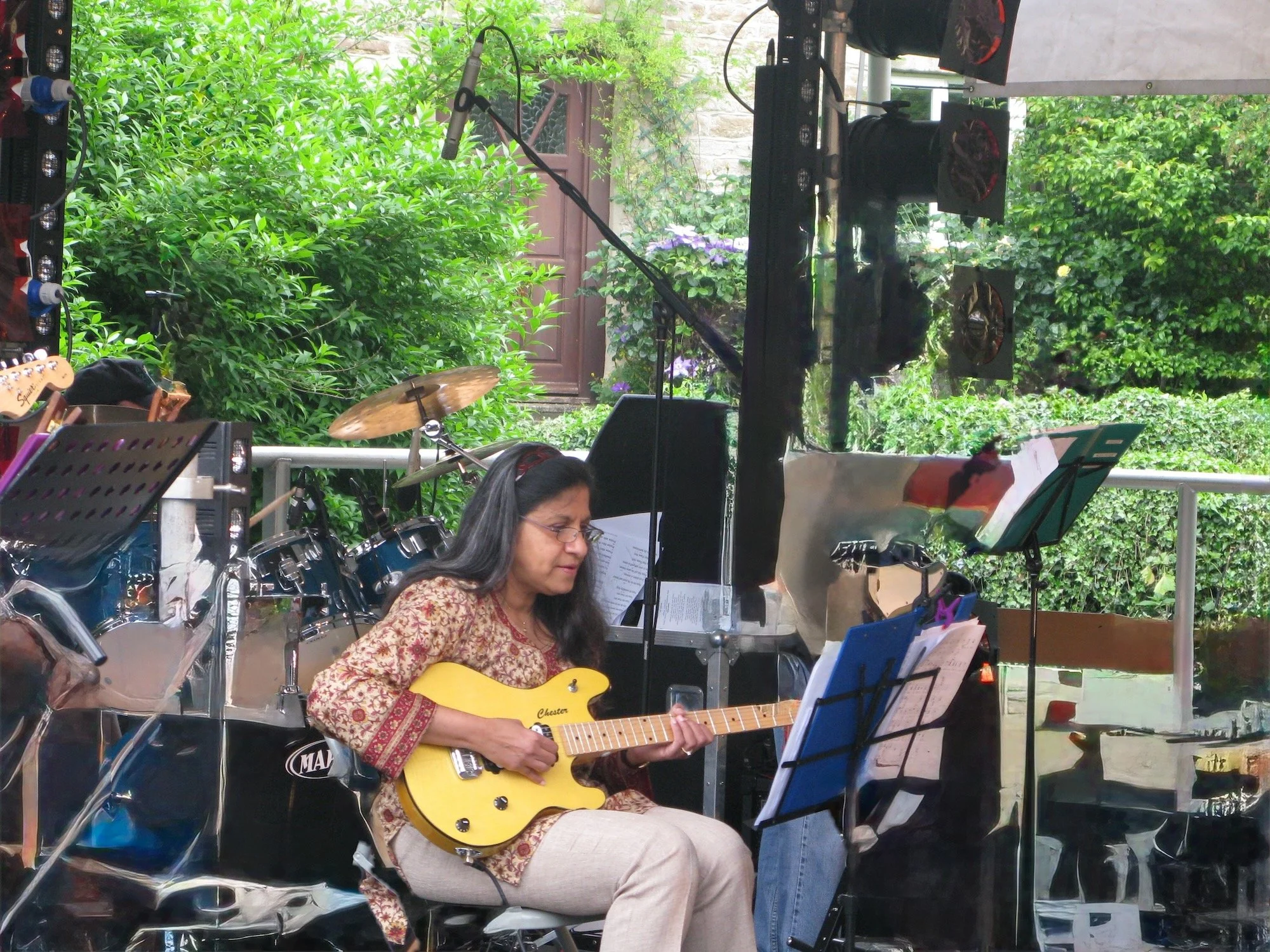 Leilani playing guitar in a Band in a local village