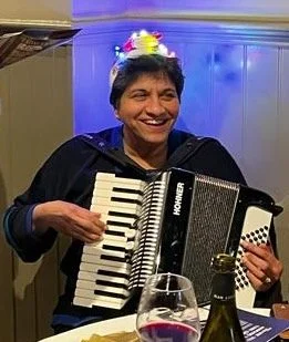 The artist playing the accordion, expressing her passion for creativity and the joy of artistic expression in everyday life.