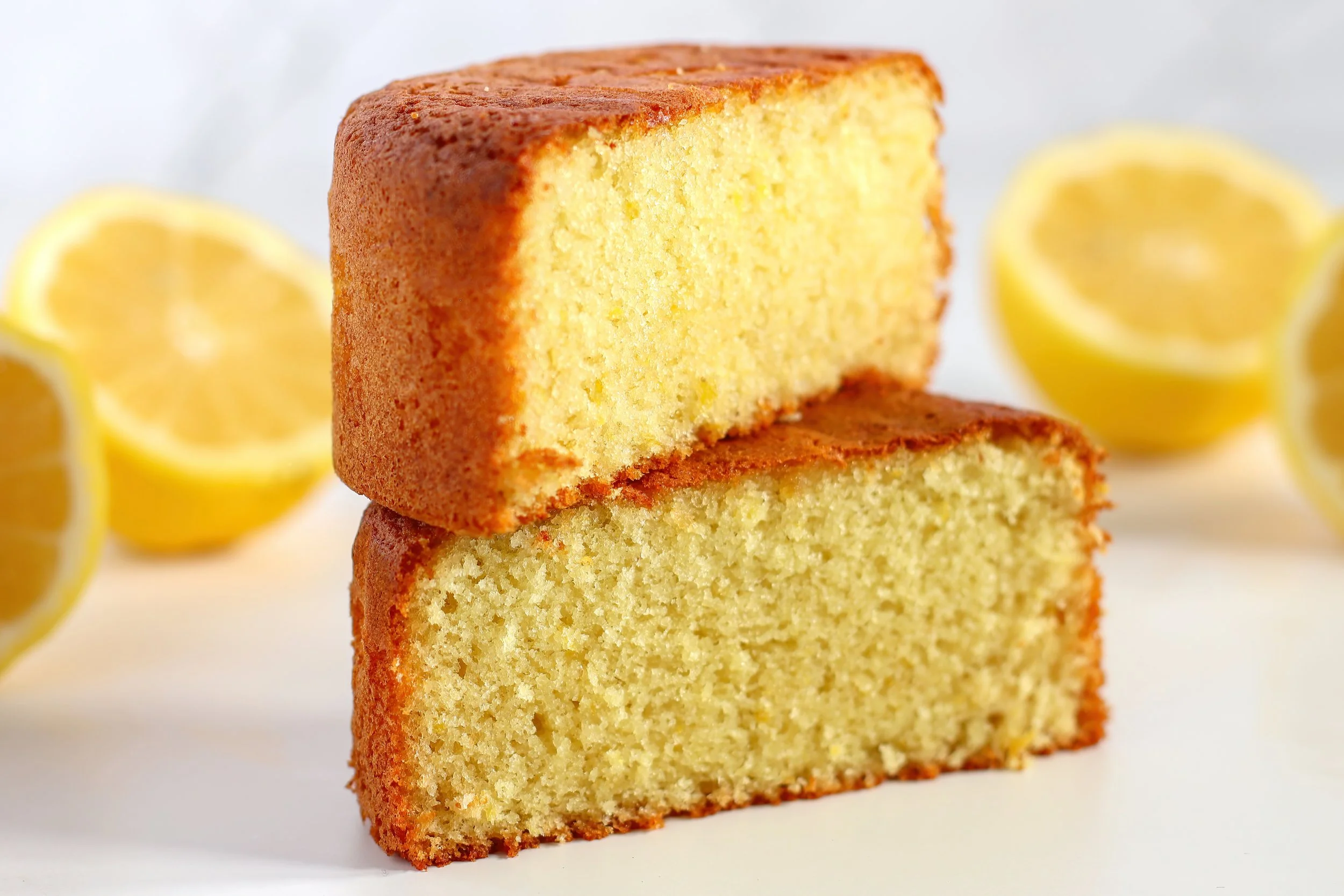 A close-up cross-section of a soft and fluffy lemon sponge cake, showcasing its tender crumb and bright, citrusy color.