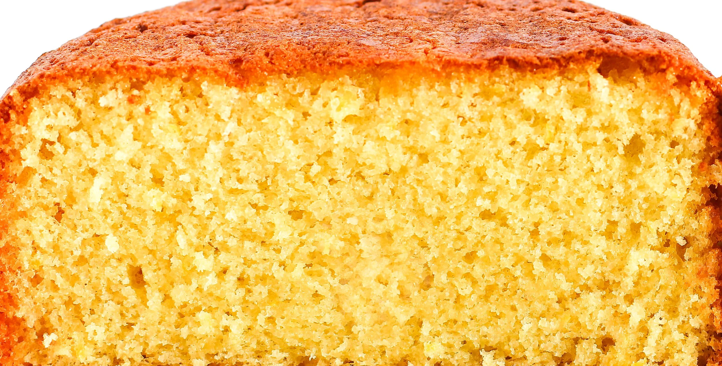 Close-up of lemon sponge cake cross-section showing airy, even crumb and golden edges