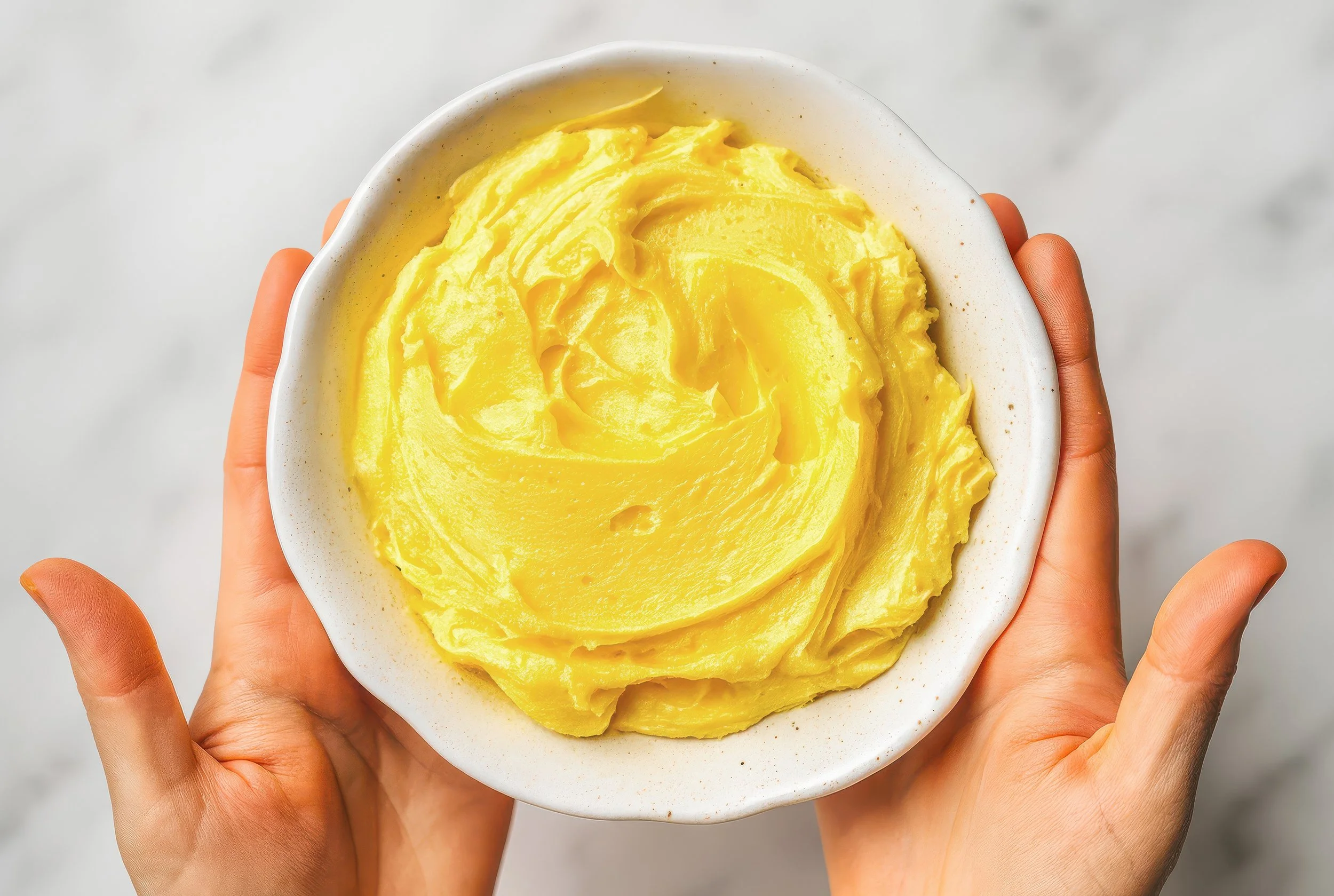 Freshly made lemon curd ganache, bright and smooth in a mixing bowl.