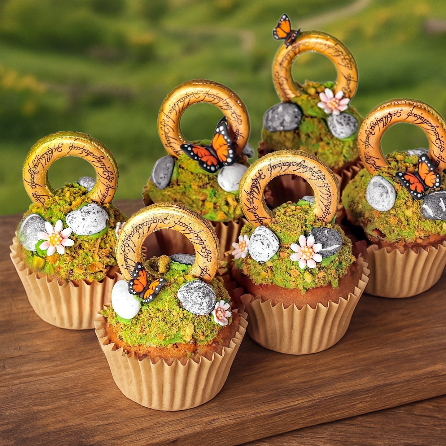 Designed with hobbit hearts and elven lore in mind, these cupcakes layer honey-apricot sponge, pistachio frosting, cookie moss, and meticulously hand-inscribed golden rings. A richly textured tribute to epic storytelling in edible form.