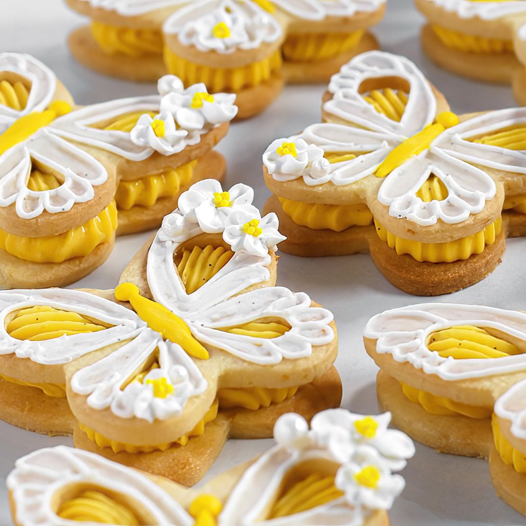 As bright and delicate as a spring day, these lemon pâte sablée cookies are filled with silky lemon curd ganache and decorated with lacy royal icing and sugar flowers. Wing cut-outs reveal the citrusy filling inside—like a miniature tart taking fligh