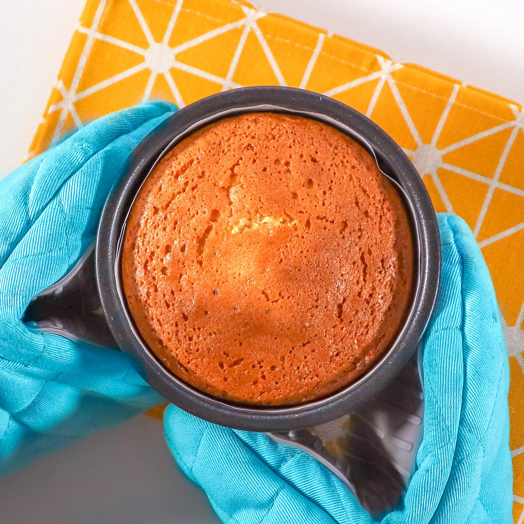 Golden brown lemon sponge cake fresh from the oven, with a light, airy crumb and perfectly even surface.