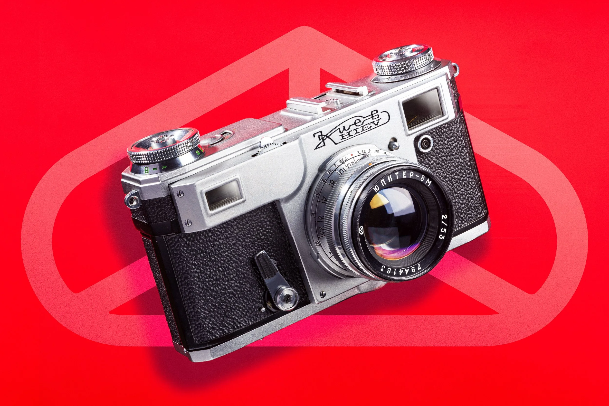 Kiev-4a Rangefinder Camera with Jupiter-8M lens attached. Floating on a red background.