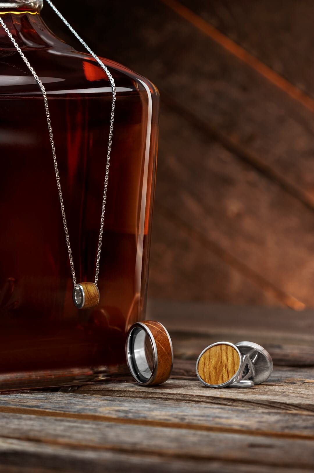 This whiskey barrel oak jewelry is displayed in a rustic setting with the source of its amber color.