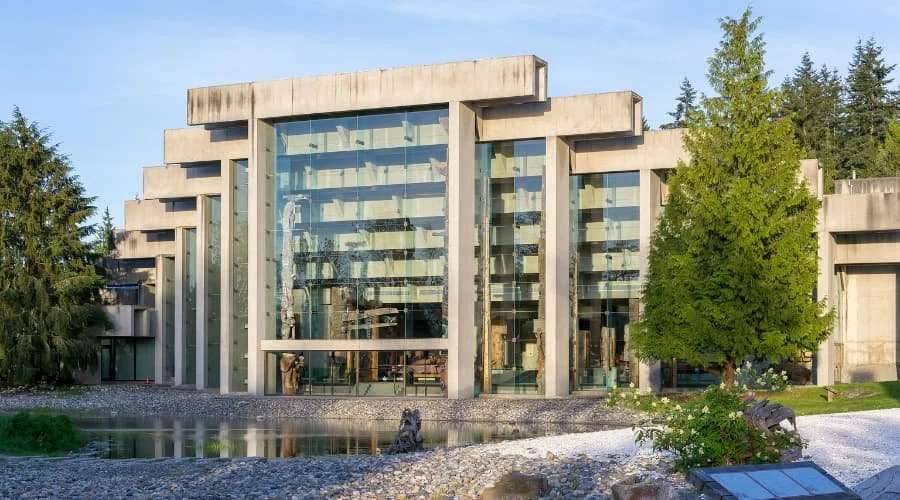 A photo of the MOA in Vancouver, BC as a sample event venue. The MOA features large glass windows, surrounded by trees and a small pond in the foreground.