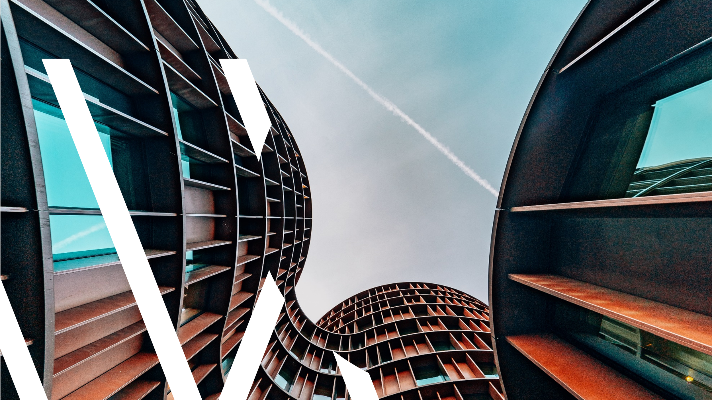 Curved modern architectural buildings with glass windows against a blue sky