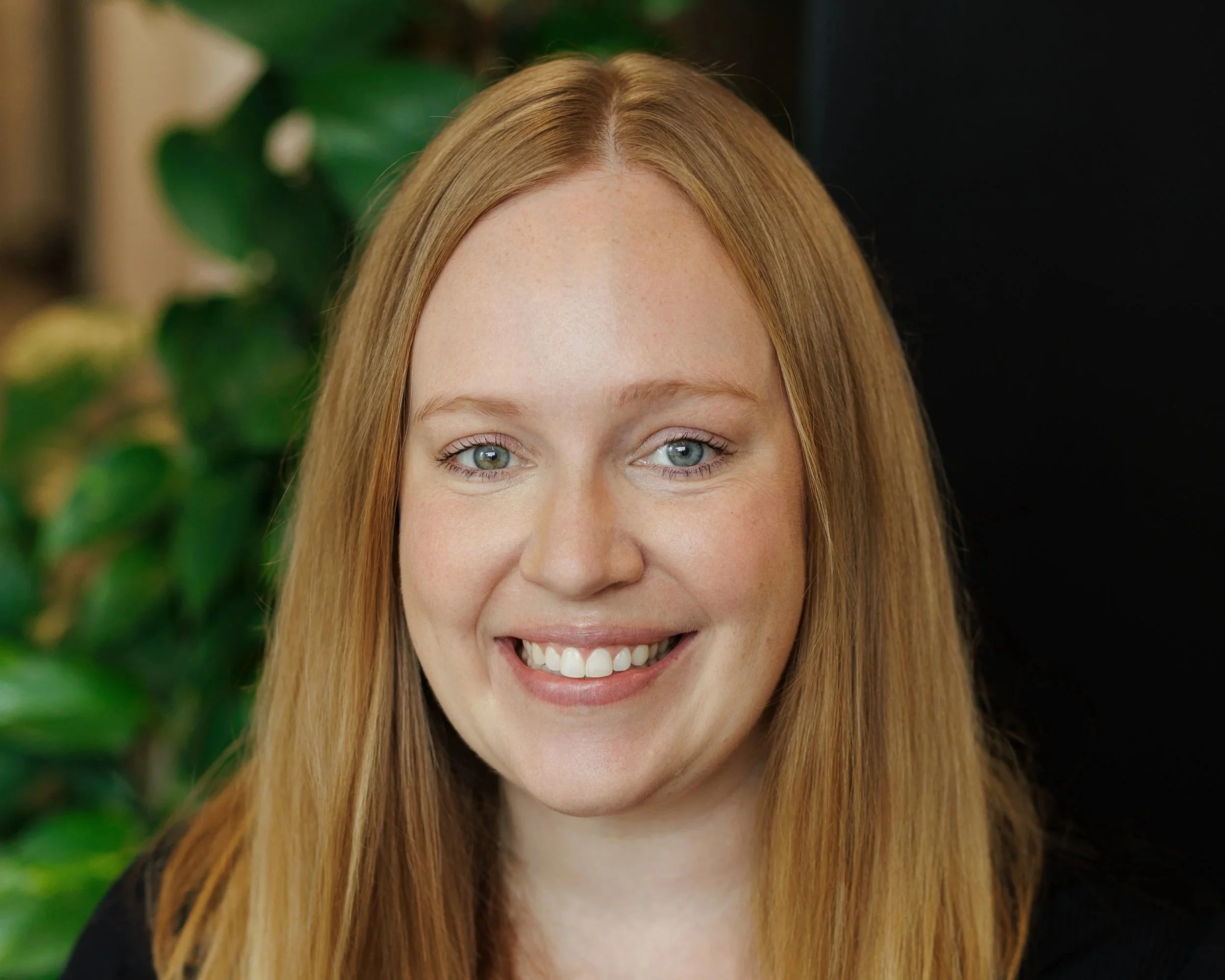 Woman with blonde hair, black shirt and smiling
