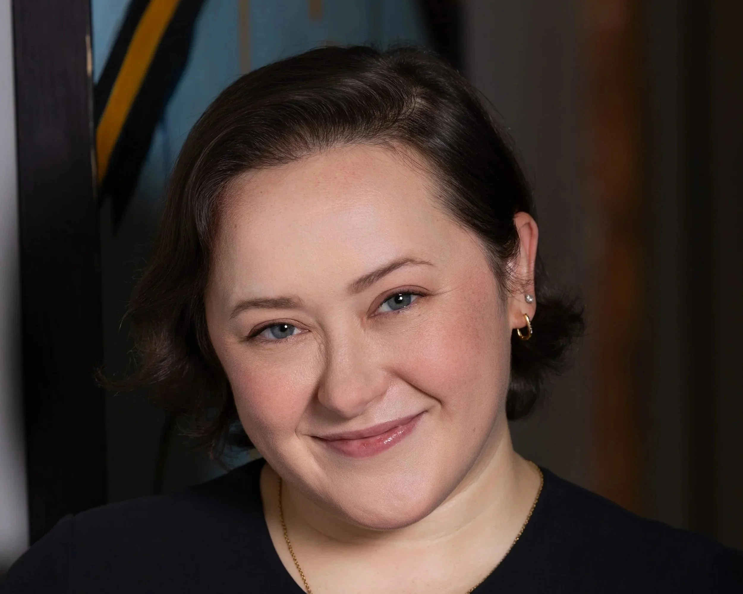 Woman with short dark brown hair and light gray shirt