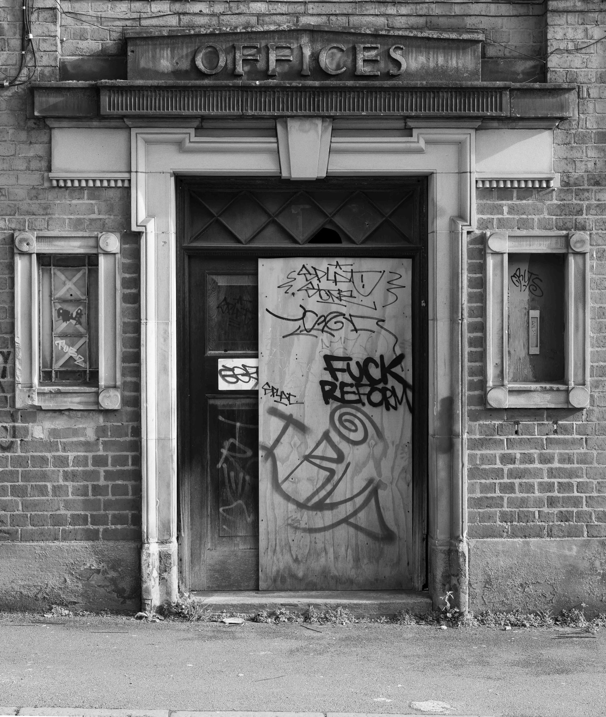 An industrial doorway on Bradford Street, Birmingham. With a graffiti comment 'Fuck Reform'
