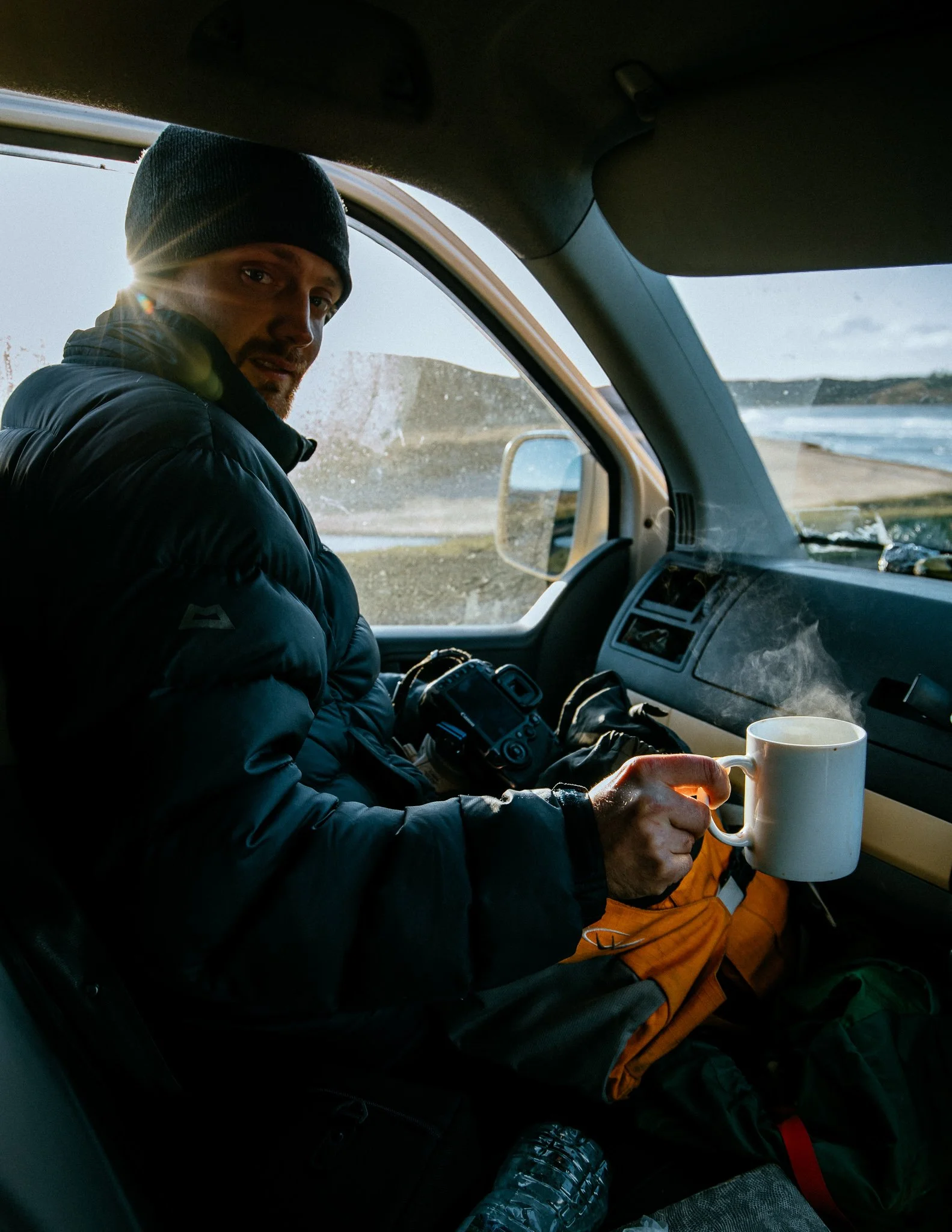 Adventure photography, man enjoying a cup of coffee in the van
