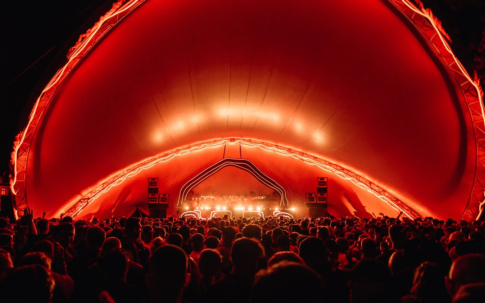  a crowd at a music festival and a big stage