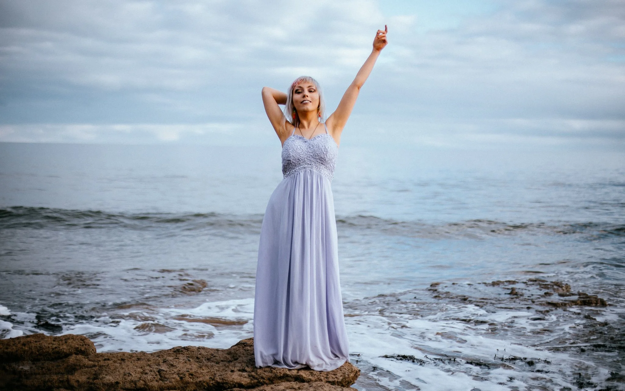  girl poses on the beach in purple dress